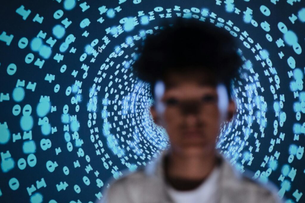 Blurred person in front of a digital code projection creating a tech-inspired abstract vibe.